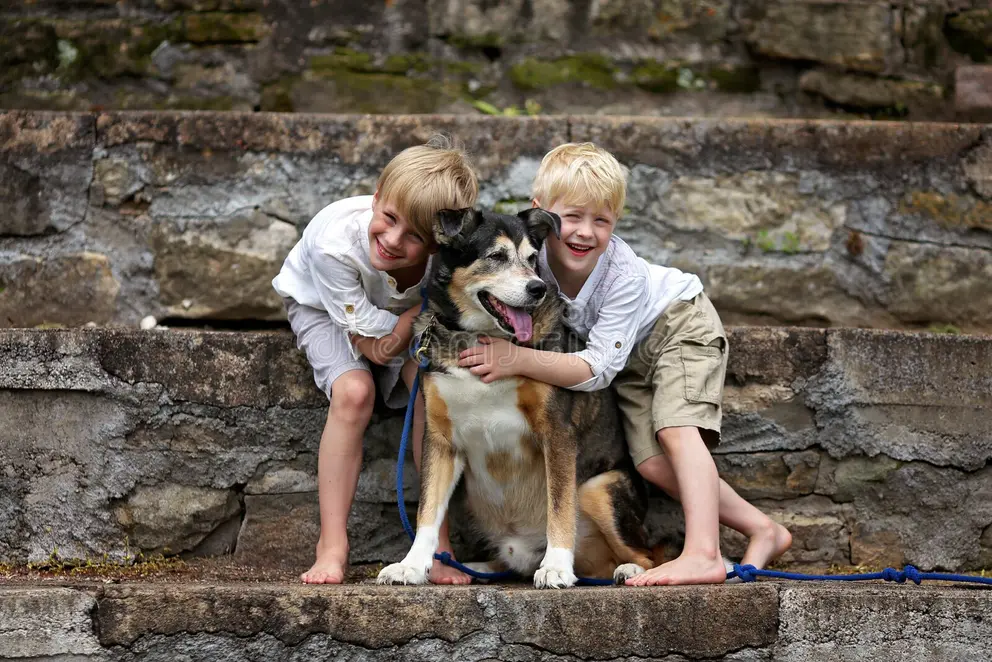 Dos niños abrazando a su perro adoptado